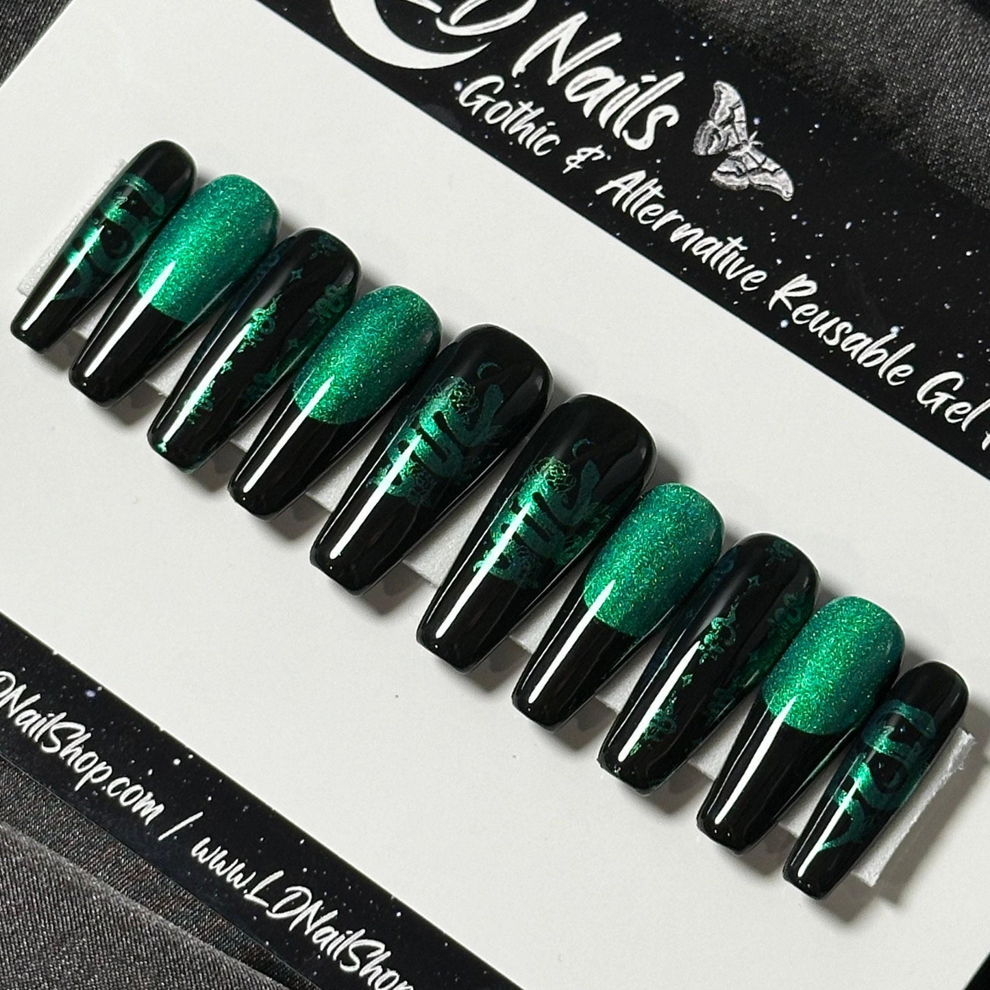 May include: Set of ten black and green reusable gel nails with a snake design. The nails are long and have a green glitter accent on the top half of each nail. The text &#39;LD Nails: Gothic & Alternative Reusable Gel&#39; is visible at the top of the image.